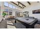 Bright game room boasts a pool table, plenty of light from many windows, and gathering spaces to accommodate many at 5850 E Ringtail Way, Phoenix, AZ 85054