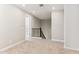A carpeted hallway features neutral walls, an open door, and a staircase with black railing at 5850 E Ringtail Way, Phoenix, AZ 85054