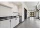 Hallway wet bar features modern cabinets, dark countertop, wine cooler, and stainless steel sink at 5850 E Ringtail Way, Phoenix, AZ 85054