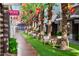 A well-maintained walkway lined with palm trees, seasonal decorations, and inviting seating in front of shops at 5850 E Ringtail Way, Phoenix, AZ 85054