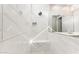 Luxurious walk-in shower featuring sleek white tiles, a comfortable bench, and modern fixtures at 5850 E Ringtail Way, Phoenix, AZ 85054
