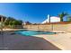 A backyard featuring a refreshing blue pool with a diving board, surrounded by a concrete patio and privacy fence at 6012 W Sweetwater Ave, Glendale, AZ 85304