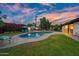 Backyard oasis featuring a large pool, lounge chairs, covered patio, green grass, and mature landscaping at 7042 N 12Th Way, Phoenix, AZ 85020