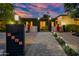 Beautiful home exterior with a gated entrance, landscaped walkway, colorful planters, and exterior lighting at 7042 N 12Th Way, Phoenix, AZ 85020