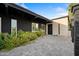 Striking home exterior with a contemporary door, lush greenery, paved front entrance, and black and white color scheme at 7042 N 12Th Way, Phoenix, AZ 85020