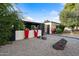 Charming home with a black and white exterior, colorful planters, decorative rock features, and a gated entrance at 7042 N 12Th Way, Phoenix, AZ 85020