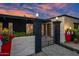 Inviting front gate with stylish brick pillars, lovely planters, and a paved walkway leading to a black and white home at 7042 N 12Th Way, Phoenix, AZ 85020