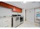 Convenient laundry room featuring modern stainless steel washer and dryer, ample cabinet storage and access to the pool at 7042 N 12Th Way, Phoenix, AZ 85020
