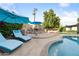 Inviting pool and outdoor kitchen with an open fireplace, seating, and beautiful backyard landscaping at 7042 N 12Th Way, Phoenix, AZ 85020