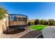 Spacious backyard featuring a trampoline and a neatly manicured artificial grass area at 706 W Green Tree Dr, San Tan Valley, AZ 85143