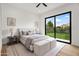 Bright bedroom featuring a ceiling fan and large window overlooking the landscaped backyard at 7157 E Bronco Dr, Paradise Valley, AZ 85253