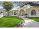 Inviting home exterior with lush lawn, tiled walkway, and arched entryway providing curb appeal at 7157 E Bronco Dr, Paradise Valley, AZ 85253