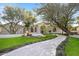Elegant home showcases a lush, landscaped front yard with mature trees and a charming walkway at 7157 E Bronco Dr, Paradise Valley, AZ 85253