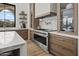 Well-equipped kitchen with a chef-grade range, custom cabinets, and a marble backsplash at 7157 E Bronco Dr, Paradise Valley, AZ 85253