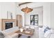 Bright living room featuring a modern fireplace, wooden beams, stylish light fixture, and outside views at 7157 E Bronco Dr, Paradise Valley, AZ 85253