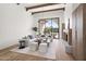 Bright, open living room with modern decor, fireplace, wooden beams, and backyard views at 7157 E Bronco Dr, Paradise Valley, AZ 85253
