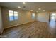 Spacious living room featuring wood-look tile flooring and ample natural light from multiple windows at 7272 E Hackamore Ln, San Tan Valley, AZ 85143