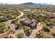 Stunning aerial view of desert home showcasing lush landscaping, mountain views, and elegant stone accents at 7413 E Lower Wash Pass, Scottsdale, AZ 85266