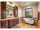 Bathroom with a freestanding tub, vanity, and luxurious tile work at 7413 E Lower Wash Pass, Scottsdale, AZ 85266