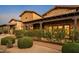 Beautiful exterior of home, boasting stone accents, large windows, mature landscaping, and an extended front porch at 7413 E Lower Wash Pass, Scottsdale, AZ 85266