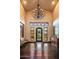 Grand foyer with chandelier, high ceilings, tile flooring, decorative art, and ornate wrought iron front door at 7413 E Lower Wash Pass, Scottsdale, AZ 85266