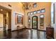 Grand foyer with chandelier, high ceilings, hardwood flooring, decorative art, and ornate wrought iron front door at 7413 E Lower Wash Pass, Scottsdale, AZ 85266