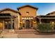 Lovely home displaying unique architecture, stone and stucco, and an inviting arched front door at 7413 E Lower Wash Pass, Scottsdale, AZ 85266