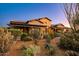 Desert landscaping surrounds the entrance of this southwestern-style home with stone and stucco exterior at 7413 E Lower Wash Pass, Scottsdale, AZ 85266