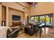 Bright living room featuring a fireplace, tile floors, leather chairs and large windows with backyard views at 7413 E Lower Wash Pass, Scottsdale, AZ 85266