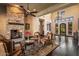 Living room features stone fireplace, high ceilings, hardwood flooring, chandelier, and ornate wrought iron front door at 7413 E Lower Wash Pass, Scottsdale, AZ 85266