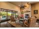 Inviting living room showcasing a stone fireplace, wood floors, and sliding doors to the backyard pool at 7413 E Lower Wash Pass, Scottsdale, AZ 85266