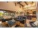 Open-concept living room showcasing high ceilings, leather furniture, and kitchen access with backyard views at 7413 E Lower Wash Pass, Scottsdale, AZ 85266