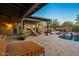 Charming outdoor patio featuring a stone fireplace and cozy seating near a pool at 7413 E Lower Wash Pass, Scottsdale, AZ 85266