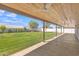 Covered back patio with ceiling fan overlooking the spacious backyard and blue skies at 8049 E Des Moines St, Mesa, AZ 85207