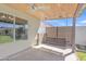 The cozy back porch features a charming wood swing and views of the sunny backyard at 8049 E Des Moines St, Mesa, AZ 85207