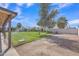 Expansive backyard with lush lawn, mature trees, and an automatic sprinkler system at 8049 E Des Moines St, Mesa, AZ 85207