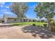 Grassy backyard with mature trees, a stone walkway and a covered back porch at 8049 E Des Moines St, Mesa, AZ 85207