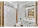 Cozy bathroom has a shower-tub, a white vanity with chrome fixtures, and a decorative mirror at 8049 E Des Moines St, Mesa, AZ 85207