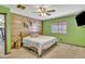 Unique bedroom features a wood accent wall, wood frame bed, neutral carpet, and a ceiling fan at 8049 E Des Moines St, Mesa, AZ 85207