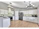 Well-lit kitchen with white cabinets, stainless steel appliances, and wood-look tile floors at 8049 E Des Moines St, Mesa, AZ 85207
