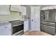 Close-up of kitchen with stainless steel fridge and range, complemented by wood floors at 8049 E Des Moines St, Mesa, AZ 85207