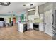 Bright eat-in kitchen features white cabinets, stainless appliances, stylish lighting, and wood-look flooring at 8049 E Des Moines St, Mesa, AZ 85207