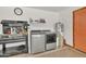 Functional laundry area with modern washer, dryer, utility sink and epoxy floor at 8049 E Des Moines St, Mesa, AZ 85207