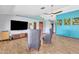 Spacious living room offers wood-look flooring, colorful walls, stylish seating, and a large television at 8049 E Des Moines St, Mesa, AZ 85207