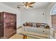 Office showcases a gun safe, leather couch, glass desk and an arched window at 8049 E Des Moines St, Mesa, AZ 85207