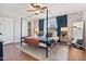 Stylish bedroom featuring a four-poster bed, modern decor, and ample natural light from the window at 8213 E Whitton Ave, Scottsdale, AZ 85251