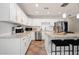 Well-appointed kitchen featuring sleek appliances, stylish white cabinets, and a large island with seating at 8213 E Whitton Ave, Scottsdale, AZ 85251