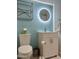 Stylish bathroom features modern fixtures, including a round illuminated mirror, a sleek vanity, and a low-flow toilet at 8302 N 21St Dr # L204, Phoenix, AZ 85021