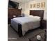 Cozy bedroom with dark wooden furniture, including a dresser with TV and a framed print above bed at 8302 N 21St Dr # L204, Phoenix, AZ 85021