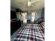 Cozy bedroom with a plaid bedspread, full closet, chair, and serene atmosphere at 8302 N 21St Dr # L204, Phoenix, AZ 85021